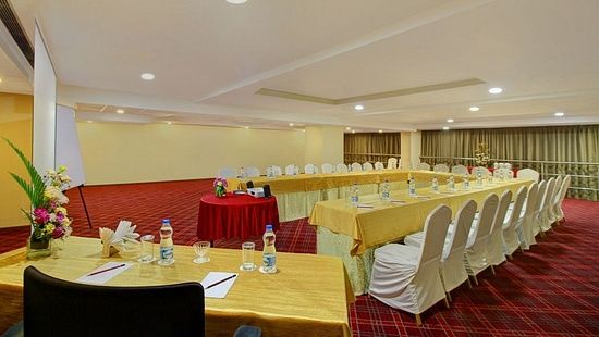 Chairs arranged in a U shape around a table for meeting purposes, seen beside a work desk and chair for a single person - Monarch Hotels