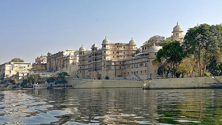 A lower angle view of a palace from the lake point with clear blue sky in the background.