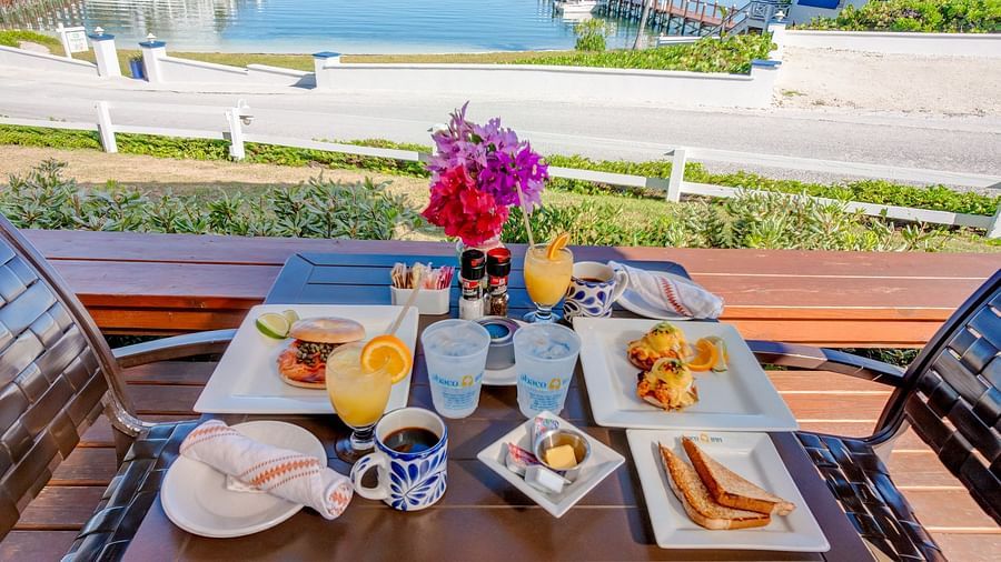 Breakfast plates on a wooden table near the sea | Abaco Inn