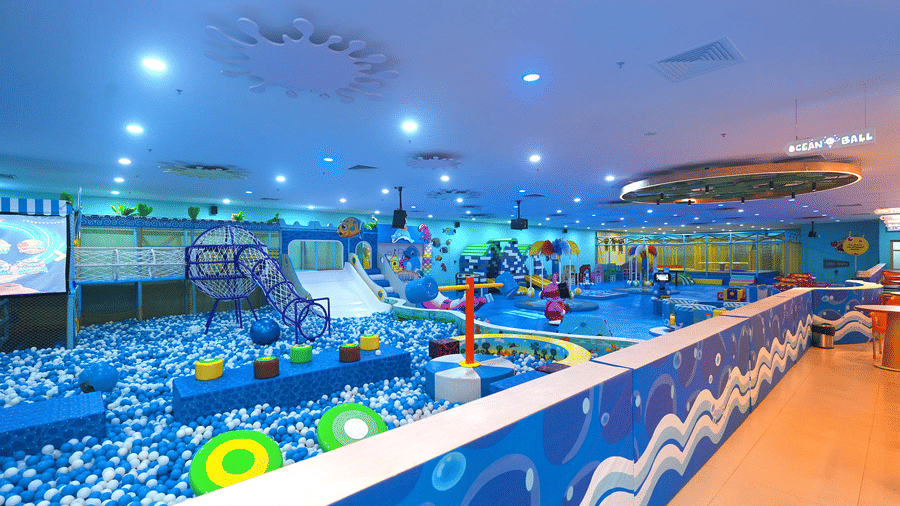 The expansive indoor playground at Tic Tac Tot features a large ball pit, slides, and climbing obstacles.