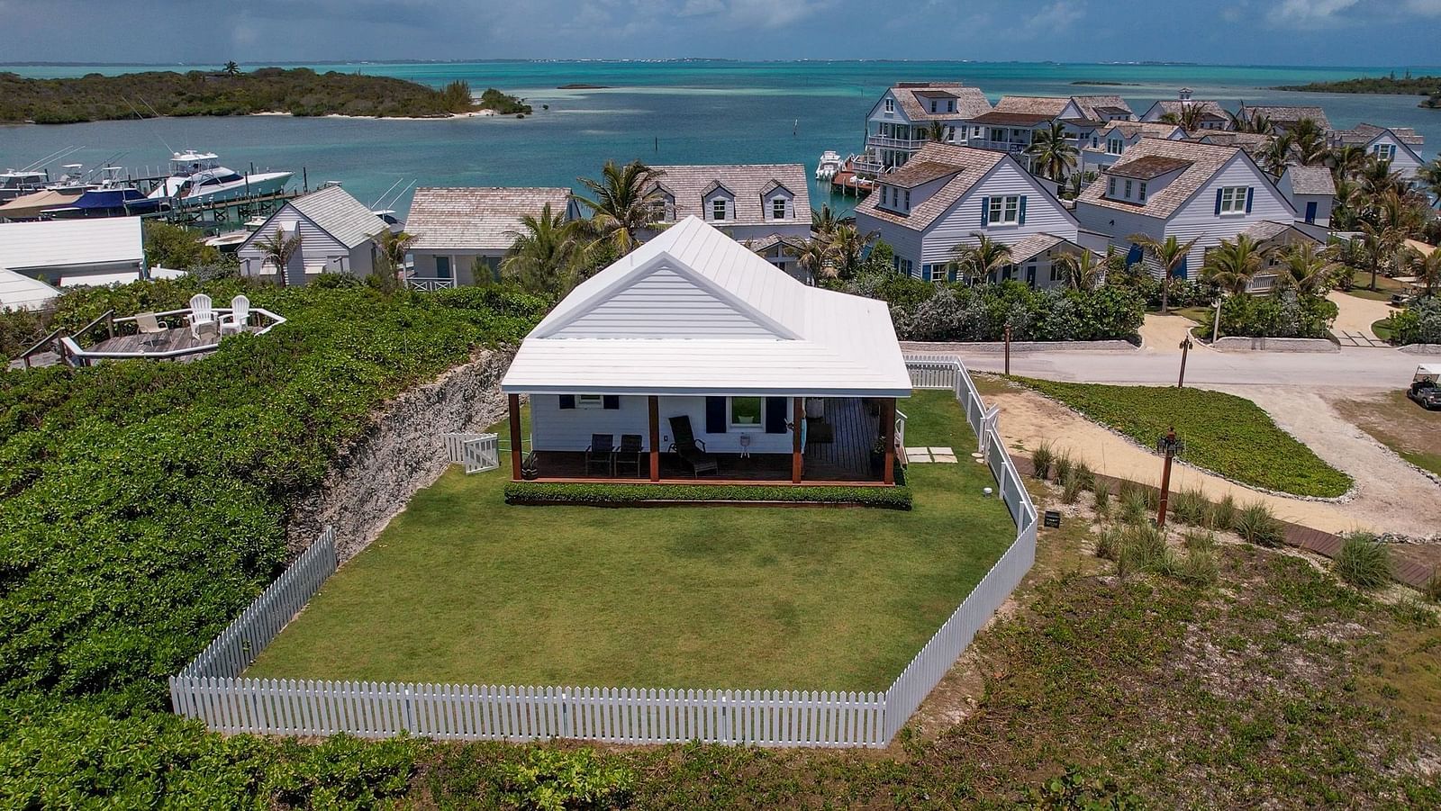 Rear view of Hill Top Cottage at Abaco Inn, surrounded by open space and pathways.