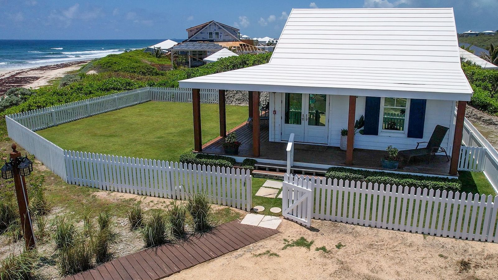 Exterior of Hill Top Cottage at Abaco Inn shown from the path leading to the porch.
