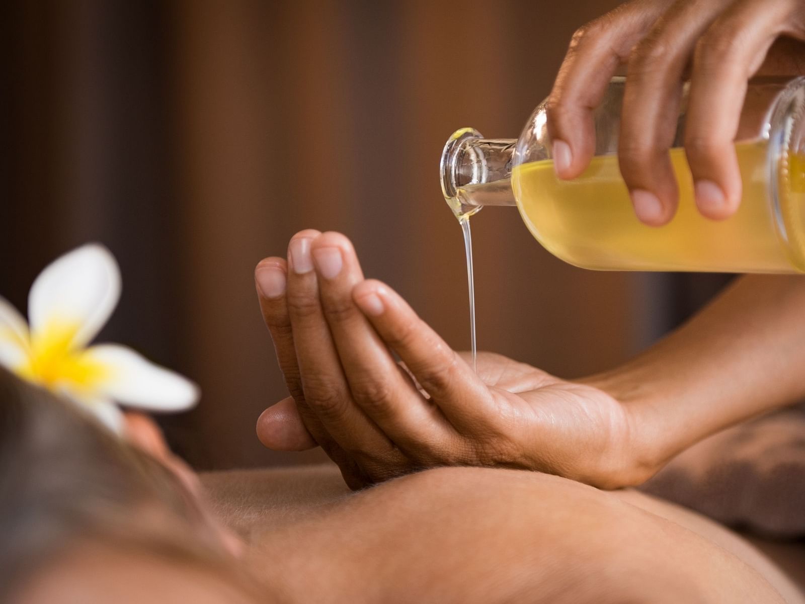 an image of a person pouring oil on their hands to massage their client - Rhythm Lonavala