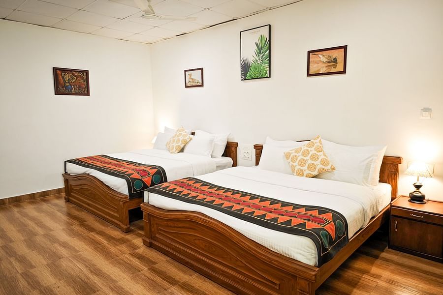 an image of a bedroom with pillows and illuminating yellow lamps on each sides at Ibex Stays & Trails, Valparai (Mistly)