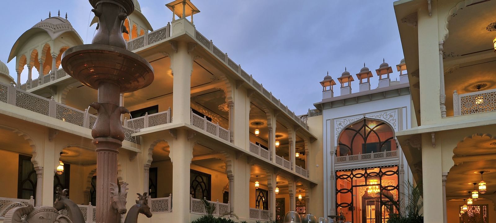 Facade of Rajasthali Resort & Spa Jaipur with lights glowing from the inside.