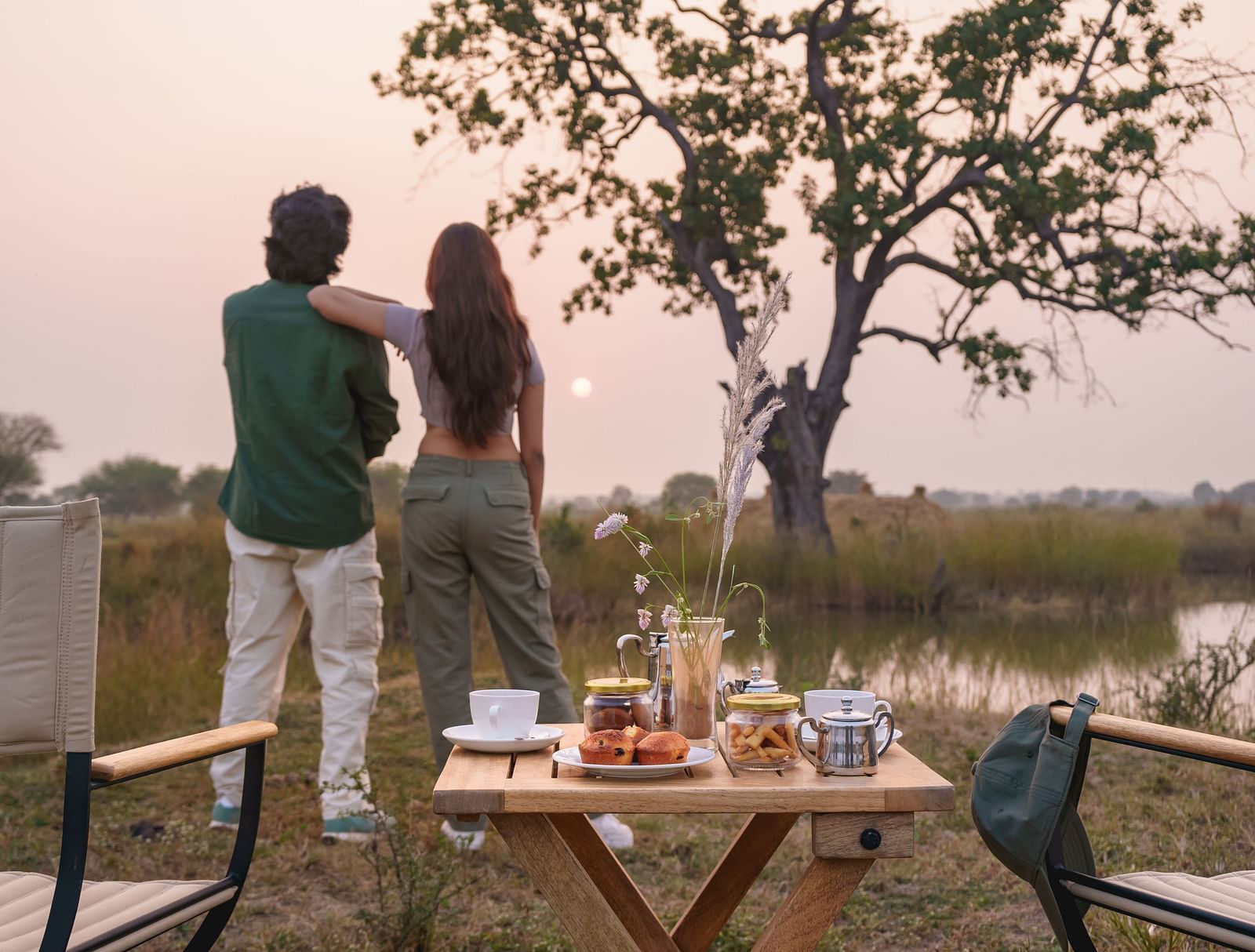 Couple watching a sunset with a dining setup at Trees N Tigers, Tadoba.