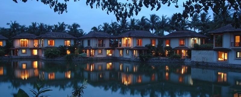 A picturesque night scene of illuminated buildings reflected in a calm body of water