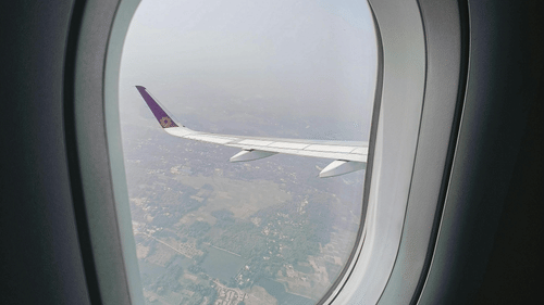 A view of the fields from a plane window on a sunny day.