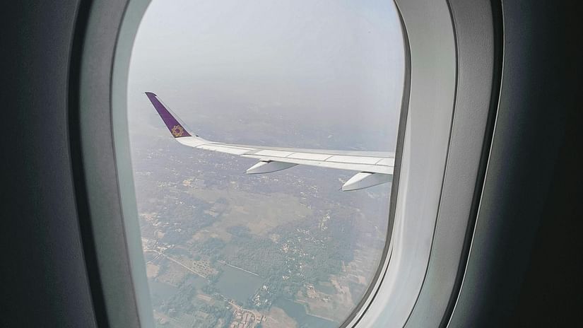 A view of the fields from a plane window on a sunny day.