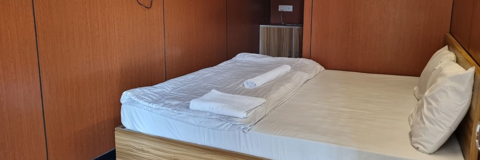 A double bed with pillows and a comforter placed over it at the Dream Vision Guest House.