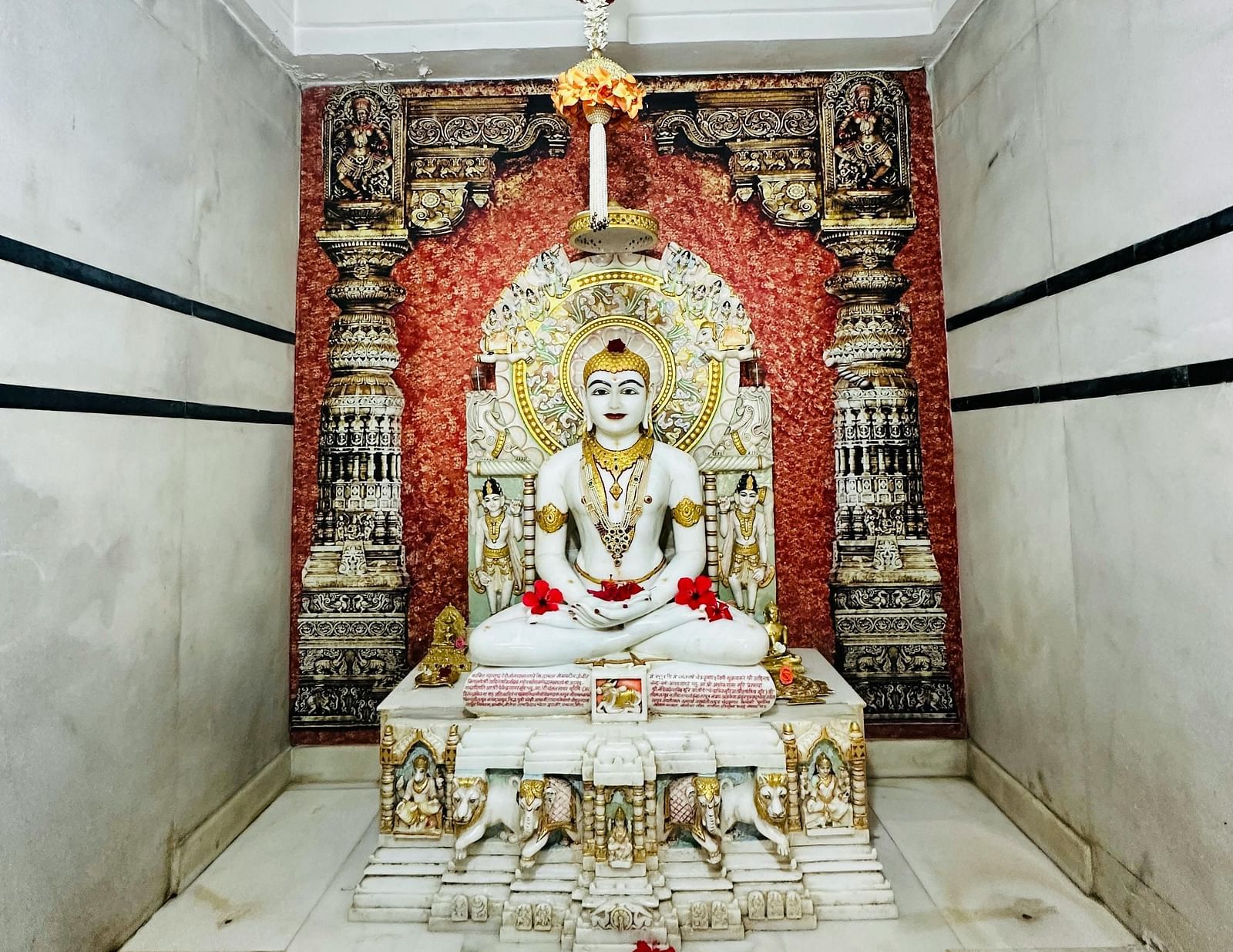 a statue of a Jain god made of white marble kept in a temple