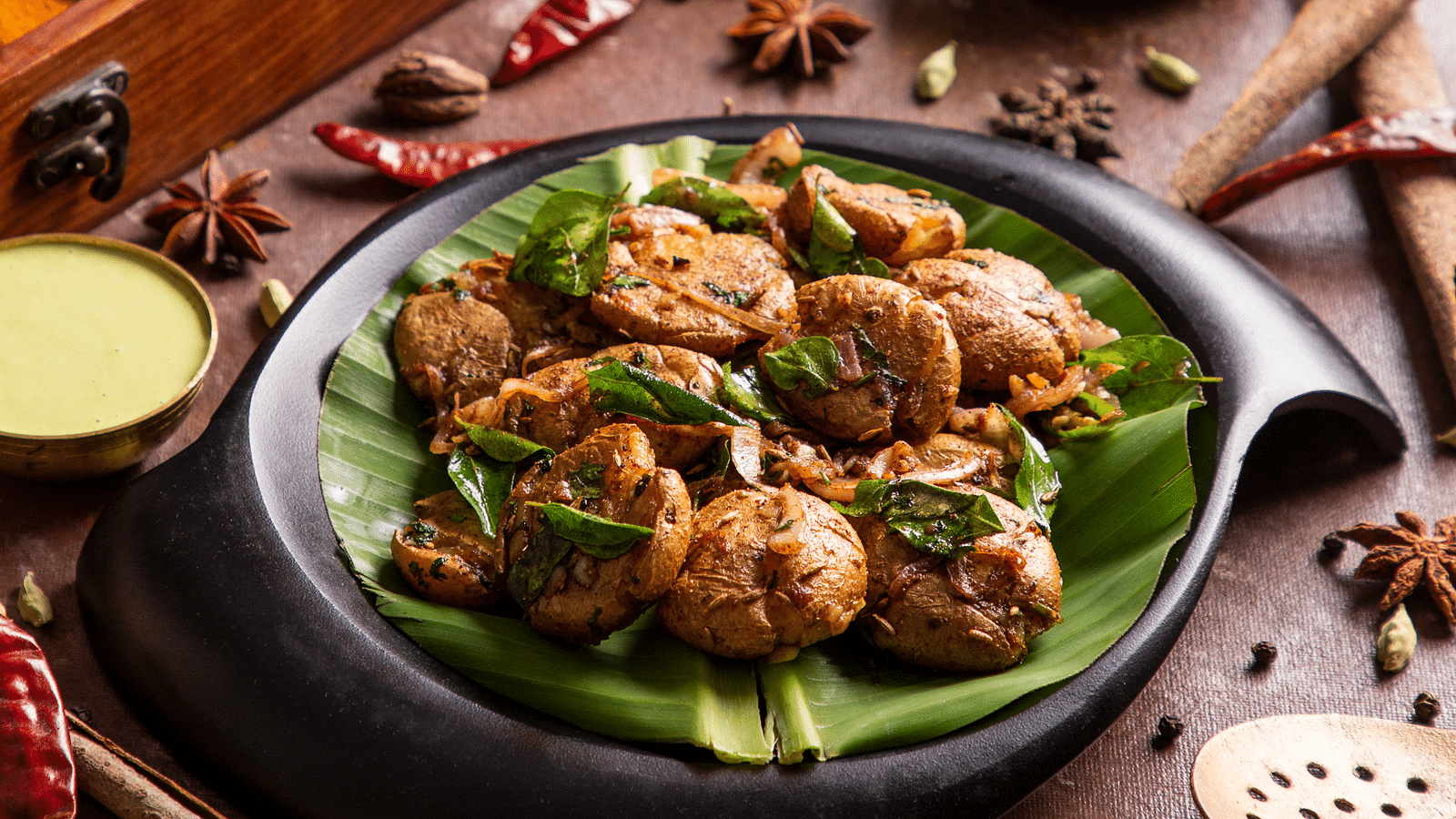 Exotic Indian spices and food served in a modern black dish. | Kamats India