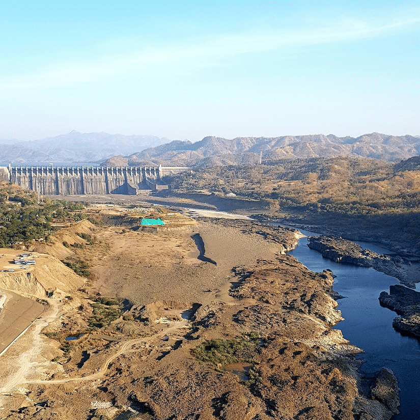 A far out view of Sardar Vallabh Bhai Patel Dam on Narmada River, surrounded by mountains and hills. 