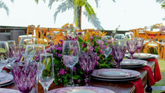 Outdoor dining setup with elegant table settings and floral arrangements.