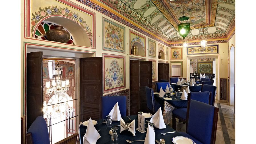Jai Niwas - Dining Hall with blue covers on chairs and tables in a long corridor  - Hotel Castle Mandawar, Jhunjunu