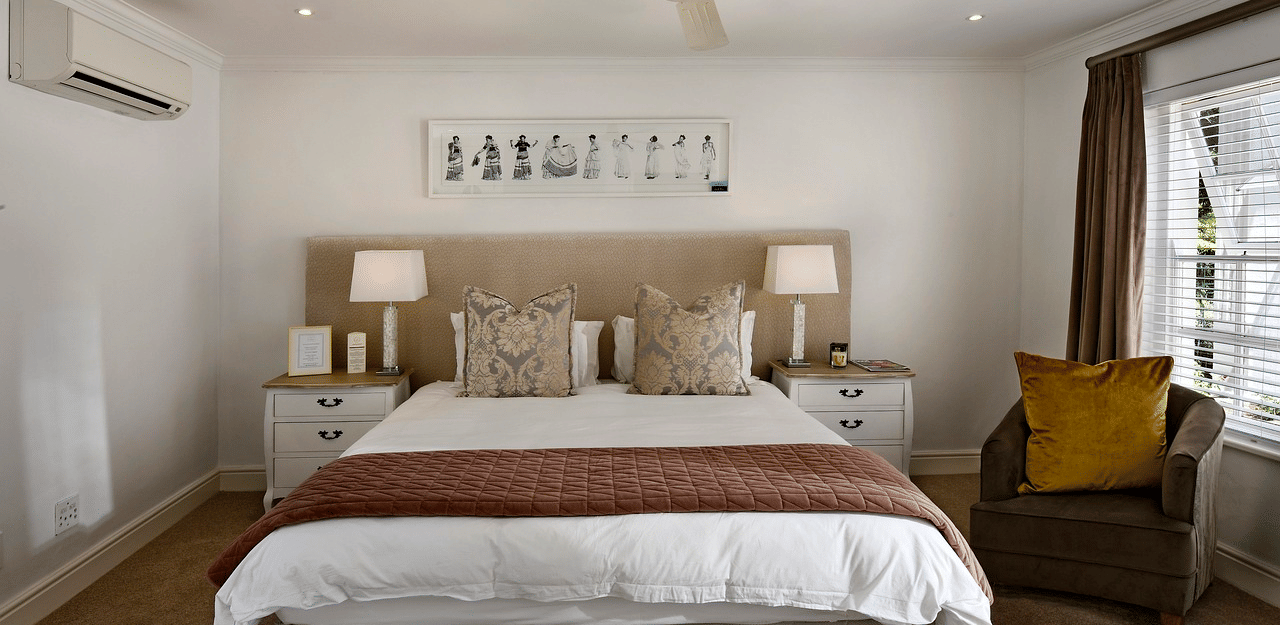 A double bed with a ceiling fan hanging over it in a bedroom.