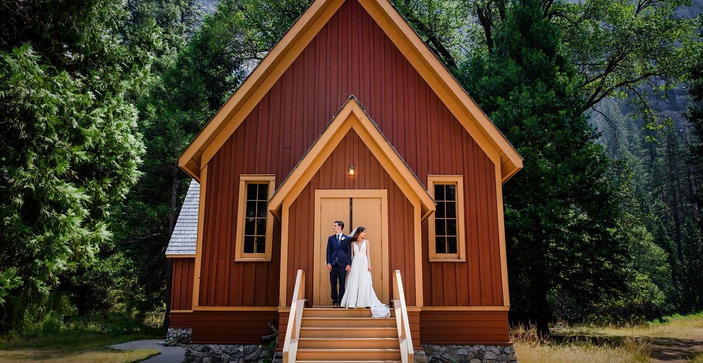A newly wed couple standing outside a church in the forests - Narrow Gauge Inn - A Serenite Hotel Near Fish Camp.