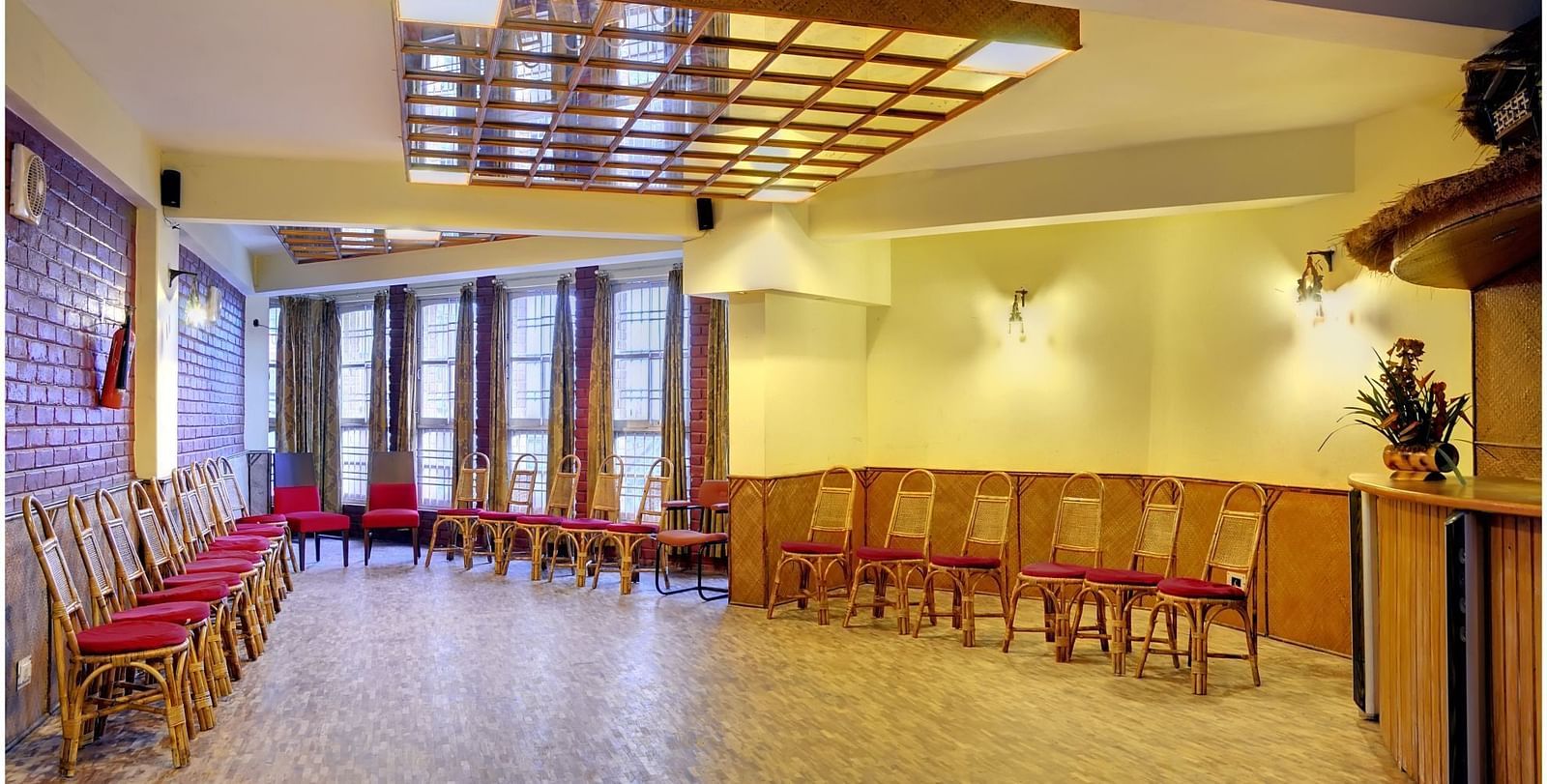 An image of a conference hall with a seating arrangement and wooden furnishing all around.