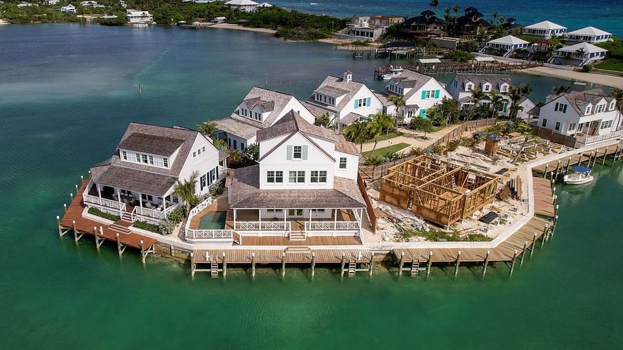 Overwater villas stretch along a calm shoreline, surrounded by a marina in a resort setting | Abaco Inn
