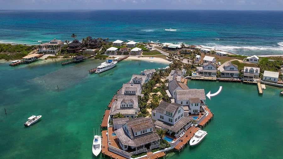 Aerial view of luxurious waterfront houses with private docs on the sea and boats docked nearby at Abaco Inn.