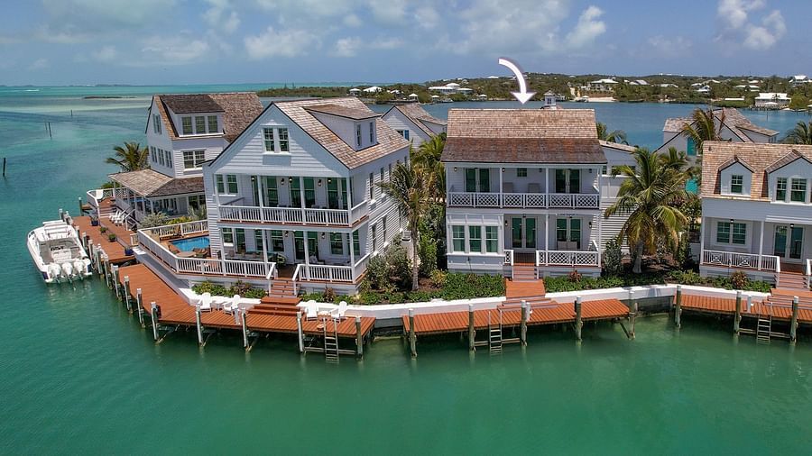 Aerial view of luxurious waterfront houses with private docs, a boat docked nearby at Abaco Inn.