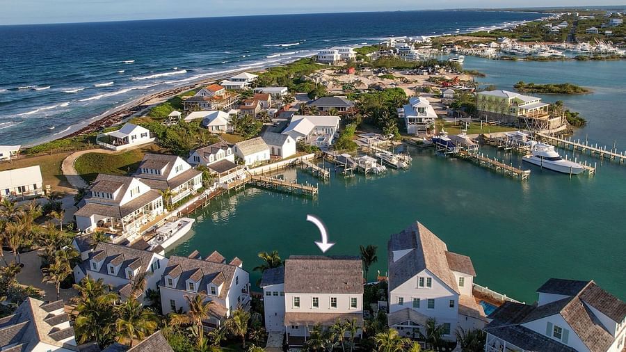 Aerial view of luxurious waterfront houses with private docs, swimming pools and a boat docked nearby at Abaco Inn.