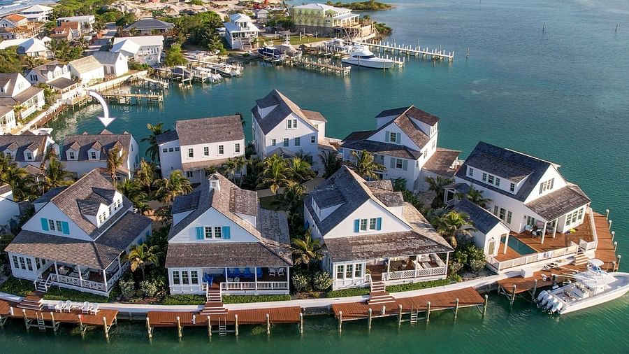 Aerial view of luxurious waterfront houses with private docs and a boat docked nearby at Abaco Inn.