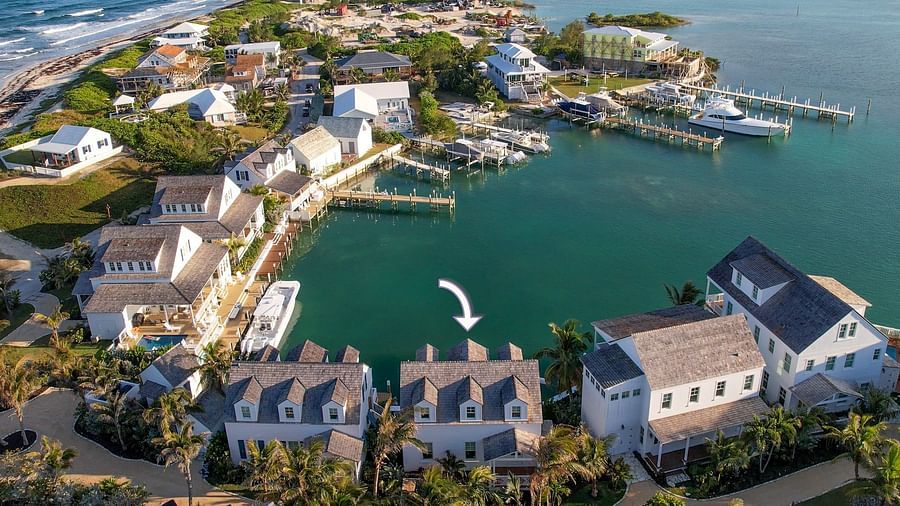 Lot-9-Aerial view of luxurious waterfront houses with private docs, and a boat docked nearby at Abaco Inn.