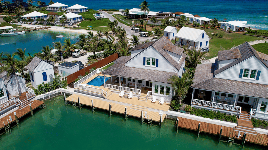 An aerial view of waterfront buildings with private docks, walkways, and surrounding ocean at Shoal Villa in Abaco Inn.
