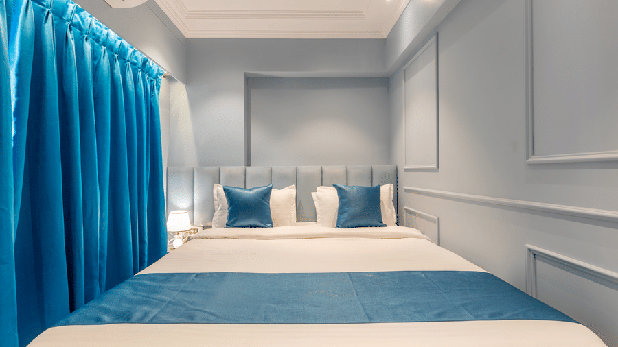 A modern bedroom with a teal and white colour scheme and soft ambient wall lighting - Home2 Residency, Mumbai Airport