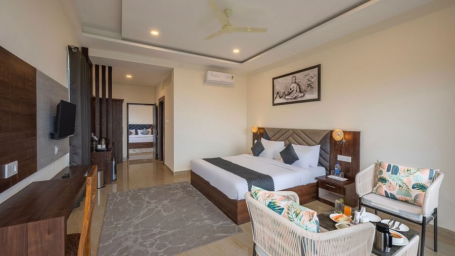 a double bed next to a sofa inside one of the rooms - Stone Wood Mountain Resort, Dharamshala - Dharamshala Best Places to Stay