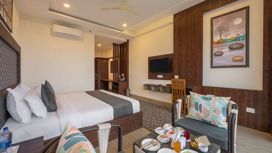 a double bed next to a sofa inside one of the rooms - Stone Wood Mountain Resort, Dharamshala