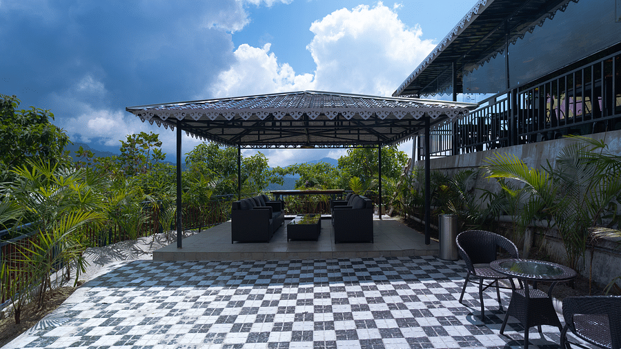 A seating area under the roof downstairs with mountain and greenery views | Voyage The Royal Retreat 