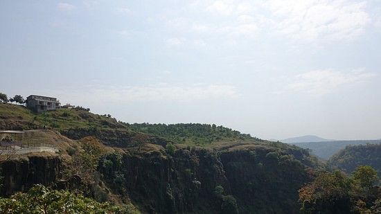 An image of a scenic hillside with a house at the top with a pathway leading up to it