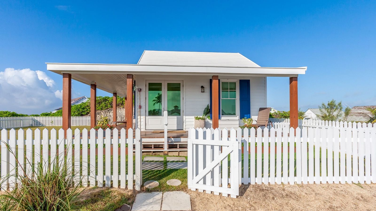 Front-facing view of Hill Top Cottage at Abaco Inn with a fenced garden and pathway.