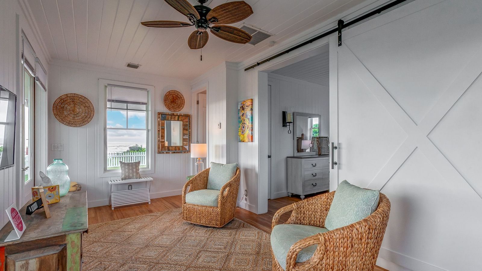 Cosy living area in Hill Top Cottage at Abaco Inn with wicker chairs and open layout.