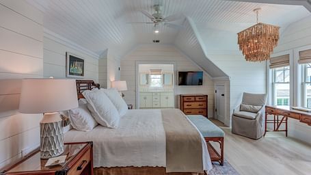 Spacious bedroom with a large bed, wicker furniture, and natural light | Abaco Inn