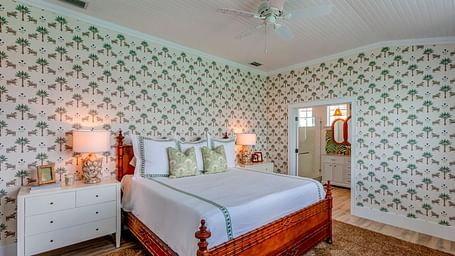 Bedroom with a bed, patterned wallpaper, and soft lighting | Abaco Inn