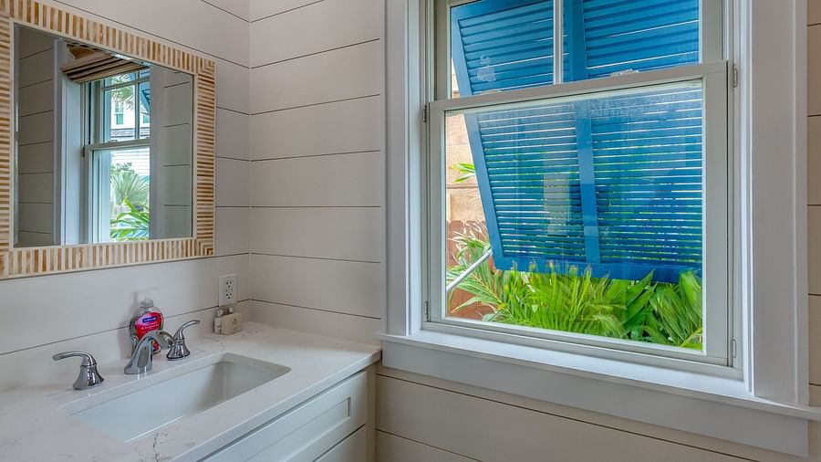 Bathroom with a window, vanity, and decorative mirror | Abaco Inn