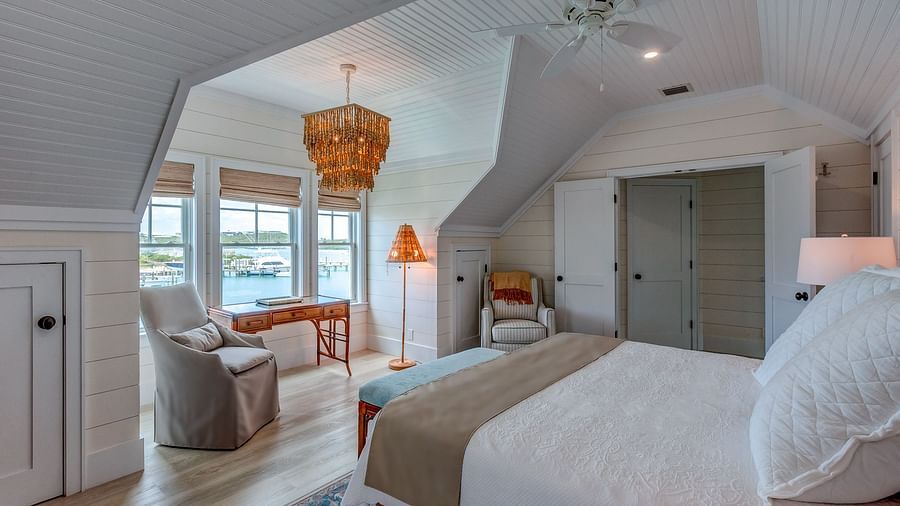 Bedroom with a king size bed, armchair, and sloped ceiling | Abaco Inn