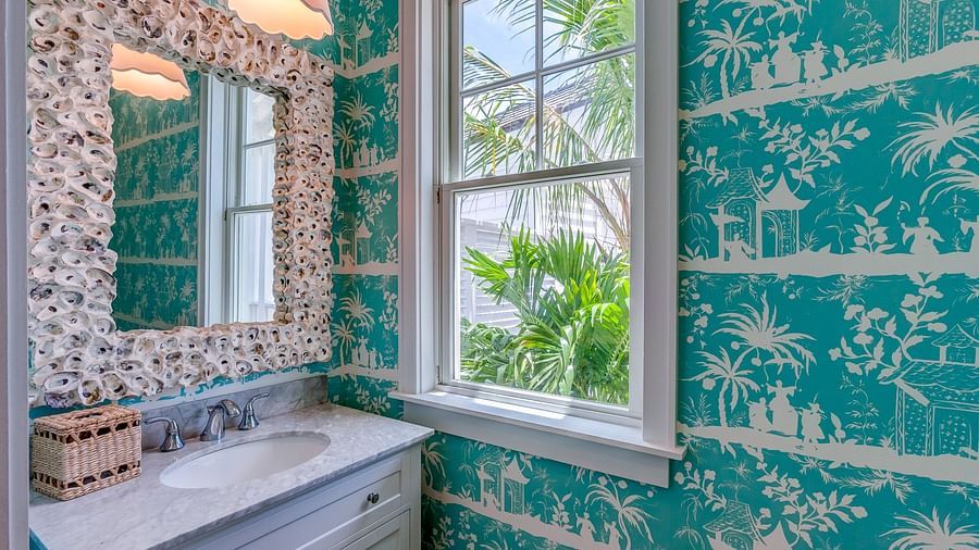Bathroom with turquoise wallpaper, a vintage mirror, and natural light | Abaco Inn