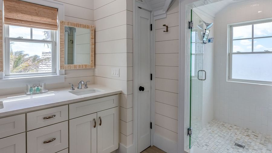 Bathroom with a window, vanity, and a built-in bathtub | Abaco Inn