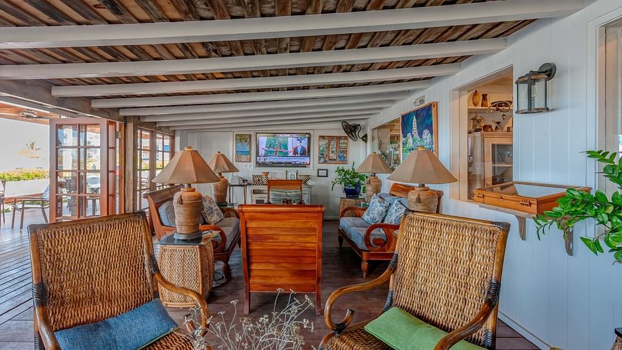Lounge with rattan chairs and bookshelves | Abaco Inn