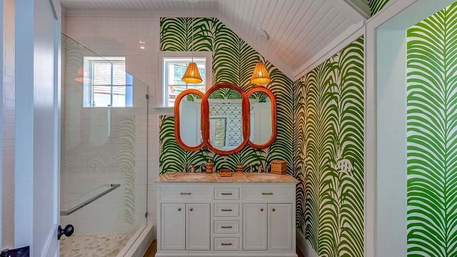 Bathroom with tropical green wallpaper, twin mirrors, and a white vanity | Abaco Inn