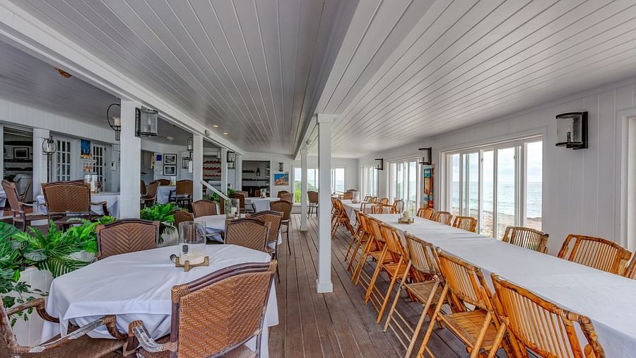 Indoor restaurant with white ceiling and wooden furniture | Abaco Inn