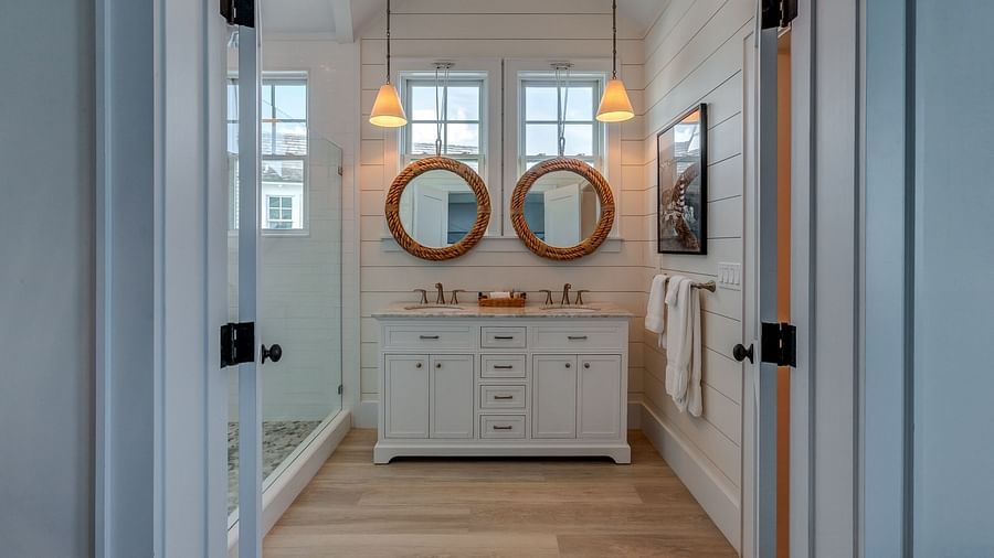 Double vanity bathroom with round mirrors and white cabinetry | Abaco Inn