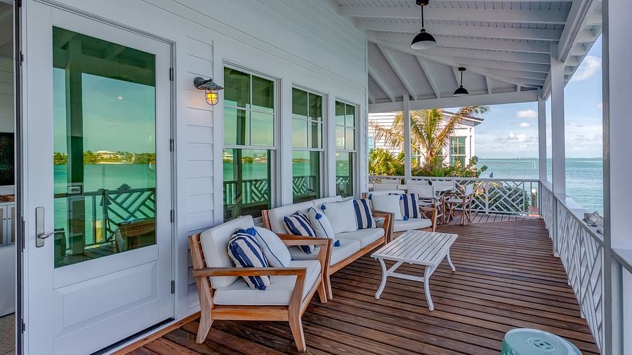 Covered patio with cushioned seating facing the ocean view | Abaco Inn