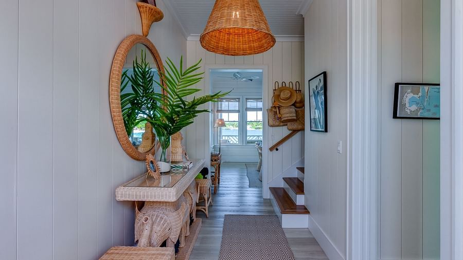 Hallway with a wooden bench, potted plant, and a hanging wicker light fixture | Abaco Inn