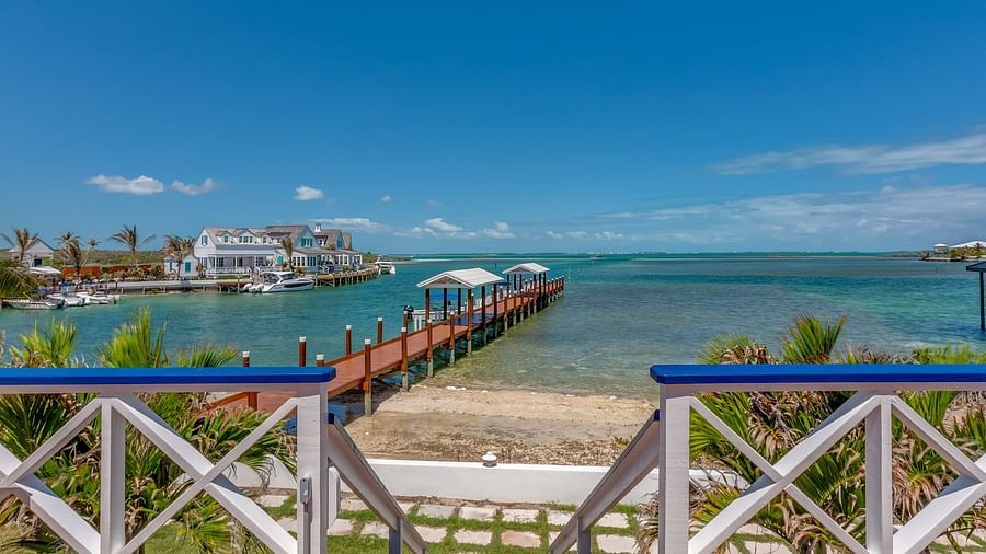 Small beach with wooden dock and calm water | Abaco Inn