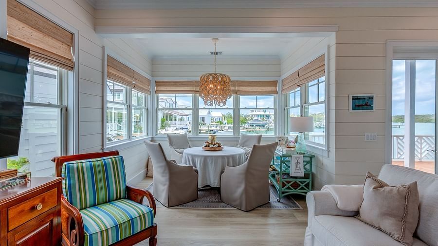 Living room with a large sectional sofa, armchairs, and waterfront views | Abaco Inn
